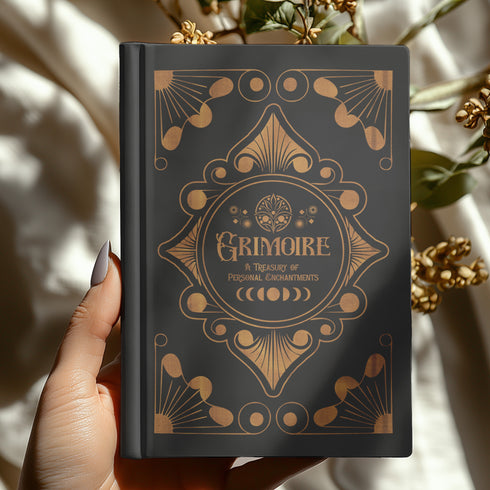 Luxurious black Grimoire with golden celestial patterns. Front reads "GRIMOIRE: A Treasury of Personal Enchantments". Back features mystical poem